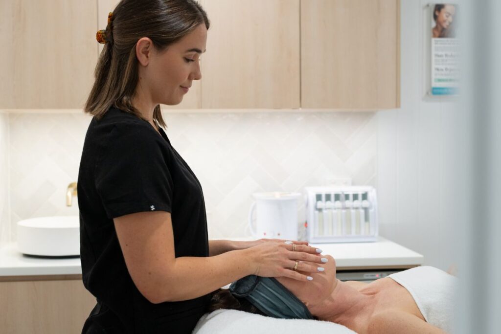Massage therapist massaging face